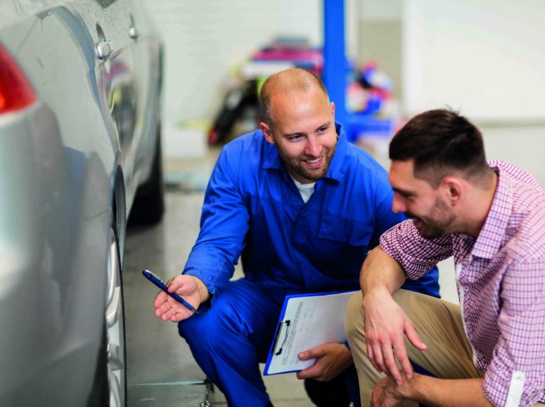 Mechaniker und Kunden besprechen Herstellergarantie beibehalten bei TOP Markenspezialist MTW-Brüggemann. Spezialist für alle Marken